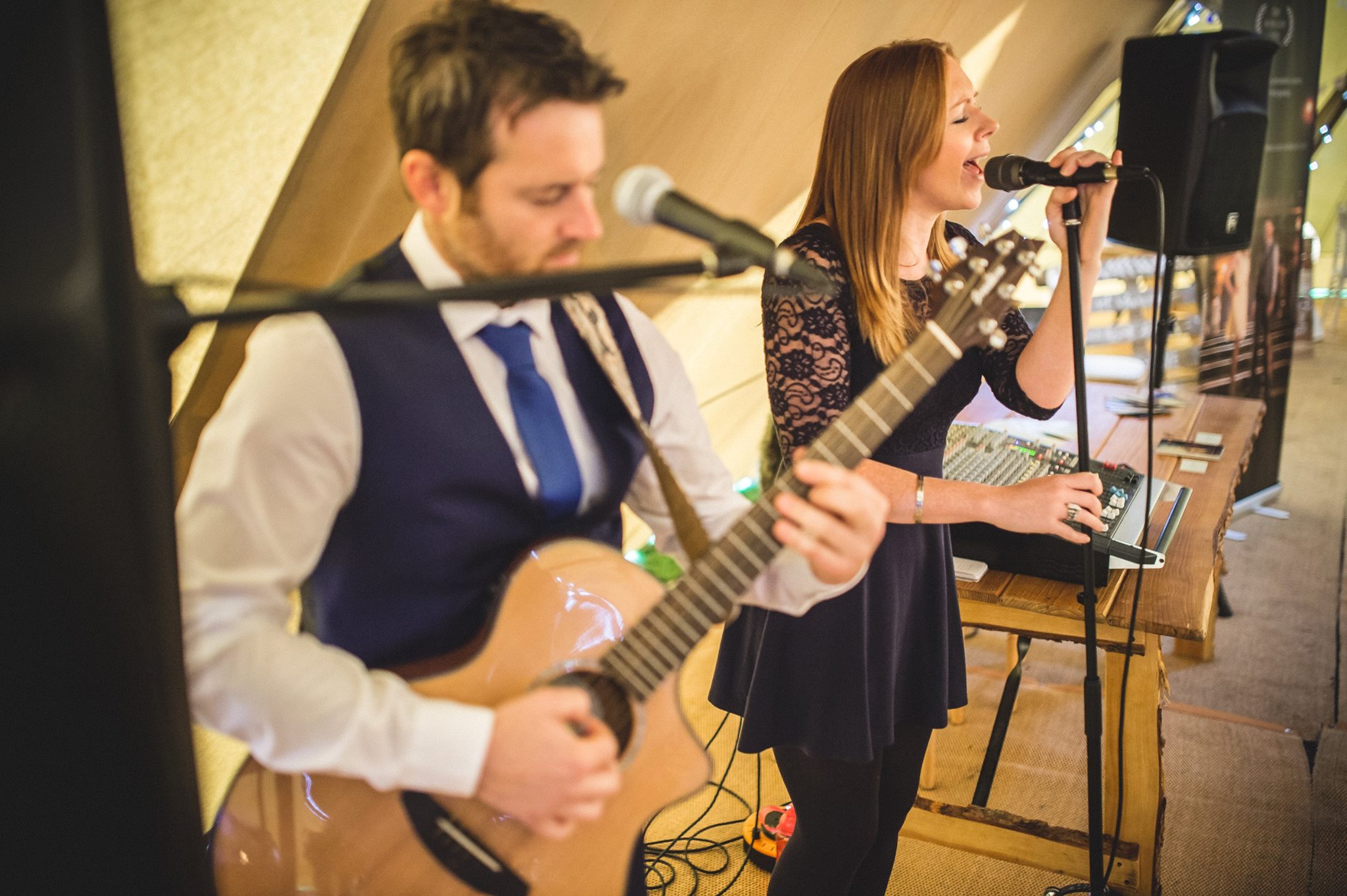 Guitarist and singer performing at wedding in tipi
